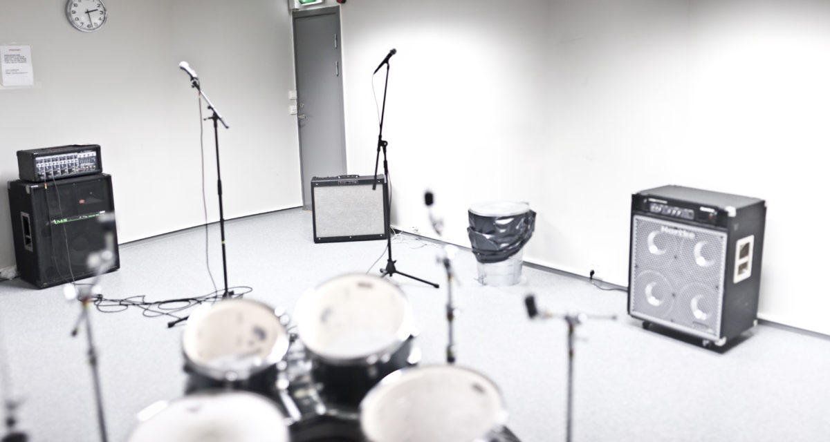 Øvingslokale med trommer, forsterker, mikrofonstativ
